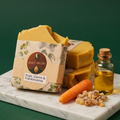 Kho-Muri soap with carrot and frankincense on a marble slab against a green background